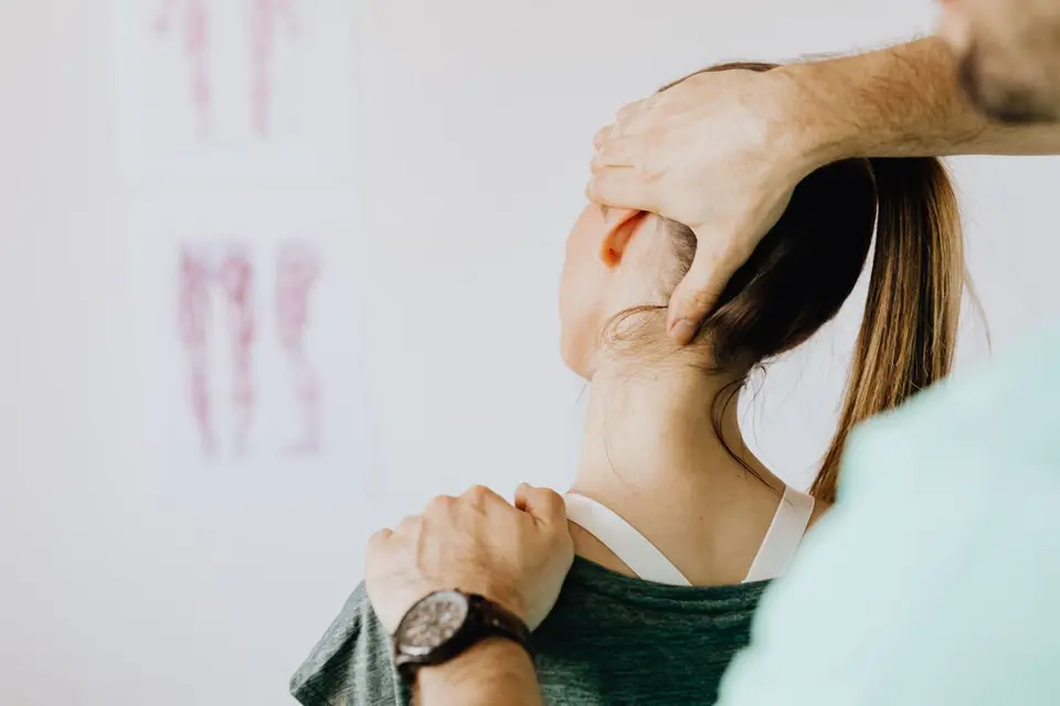 Fisioterapeuta avaliando a região cervical de uma paciente